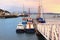 BRIXHAM, DEVON, UK, NOV 02 2015: Small boats moored at a jetty in the harbour at sunrise