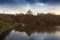 The Brno dam and above it rises the Veveri castle. Beautiful dramatic sky with autumn trees on the slopes