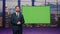 Broadcast presenter reporting daily news at television channel with green screen