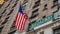 Broadway road sign. Blur American flag and buildings facade background, Manhattan downtown