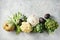 Broccoli, cauliflower, green beans, squash, and other fresh on a grey background.