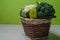 Broccoli and cauliflower with sweet peppers and porcini mushrooms. Wicker brown basket with green vegetables