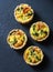 Broccoli cheddar mini savory pies on dark background, top view. Delicious appetizers
