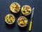 Broccoli cheddar mini savory pies on dark background, top view. Delicious appetizers, snack, tapas.