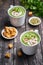Broccoli cream soup, vertical. Vegetable green puree in two large white cup. Diet vegan soup of broccoli, zucchini, green peas on