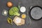 Broccoli and flour, broken egg in glass bowl, olive oil, onion and whisk