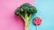 Broccoli and lollipop on a blue-pink split background. Healthy versus junk food. Diet concept. Generative AI