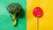 Broccoli and lollipop on a blue-pink split background. Healthy versus junk food. Diet concept. Generative AI