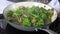 Broccoli and mushrooms sizzling in a large skillet