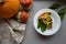 Broccoli pie on a white plate. Thanksgiving day, harvesting, autumn concept, pumpkins on gray background.