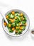 Broccoli, pumpkin warm salad on a light background, top view.