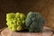 Broccoli and romanesco cauliflower on a wooden cutting board