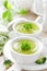 Broccoli soup in bowls on wooden kitchen table closeup. Healthy vegetarian dish