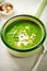 Broccoli spinach pea cream soup with cream and chilli flakes