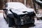 Broken, abandoned car covered with a layer of snow in the Parking lot in the city Park