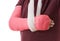 Broken arm in red plaster cast and sling