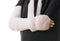 Broken arm in white plaster cast and sling