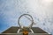 A broken basketball net dangles from a hoop attached to a metal backboard.