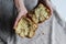 A broken cake with raisins in the hands of a girl. Homemade cake. Concept of homework during the quarantine period