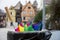 Broken colorful umbrella in garbage can, in front of colorful buildings