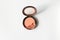 Broken crushed compact blush nude peach color on white background with copy space, top view. Simplicity beauty photo