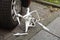 Broken drone by car wheel on footpath