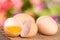 Broken egg with yolk and eggshell On a wooden table with a blurry garden background