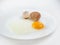 Broken eggs on a plate white background. reddish yellow.