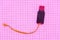 Broken flash drive with a gold cord on paper in pink color, background