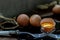 Broken fresh chicken egg Hen egg balanced on a composition of two intertwined forks and Two fresh chicken eggs over black floor