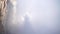 Broken ghost high in the mountains above the fog waves, surrounded by gloria. Silhouettes on a strong fog and rays of