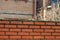 Broken glass glued to cement on top of a brick fence in a village