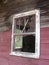 Broken Glass Window on Abandoned Red Mining Cabin