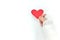 Broken hand holding a red heart in white background. Sacrificial and selfless love and genuine kindness concept.