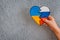 broken heart in the colors of the flag of Ukraine and Russia in children& x27;s hands on a gray background.
