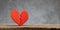 Broken heart. Crack in the red heart, Breaking the relationship. Grey background.