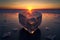 Broken heart shaped ice block on frozen icy background at sunset valentine\\\'s love concept