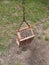 Broken kids swing with metal chain and tube supports on ground back view