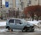 A broken light blue car without wheels is parked in the parking lot for the disabled