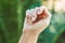 Broken nail on a woman`s hand with a manicure on a green background