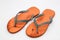 Broken orange flip flops isolated and white background