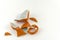 Broken orange mug on white background. Numerous pieces of the Cup