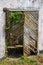 Broken and overgrown wooden door in concrete wall, Robertsport, Liberia, West Africa