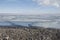 Broken pans of sea ice on ocean coast with blue sky and pebble beach along the Northwest Passage