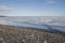 Broken pans of sea ice on ocean coast with blue sky and pebble beach along the Northwest Passage