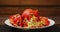 Broken ripe red pomegranate on a white plate on a wooden table rotates in a circle