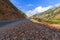 The broken road in the mountains and the dangerous bend sign.