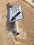 Broken road sign at a traffic island, bent to the ground after heavy impact