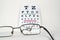 Broken Spectacles On Opticians Snellen Eye Test Chart