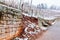 Broken Stone wall in vineyard water and snow damage.